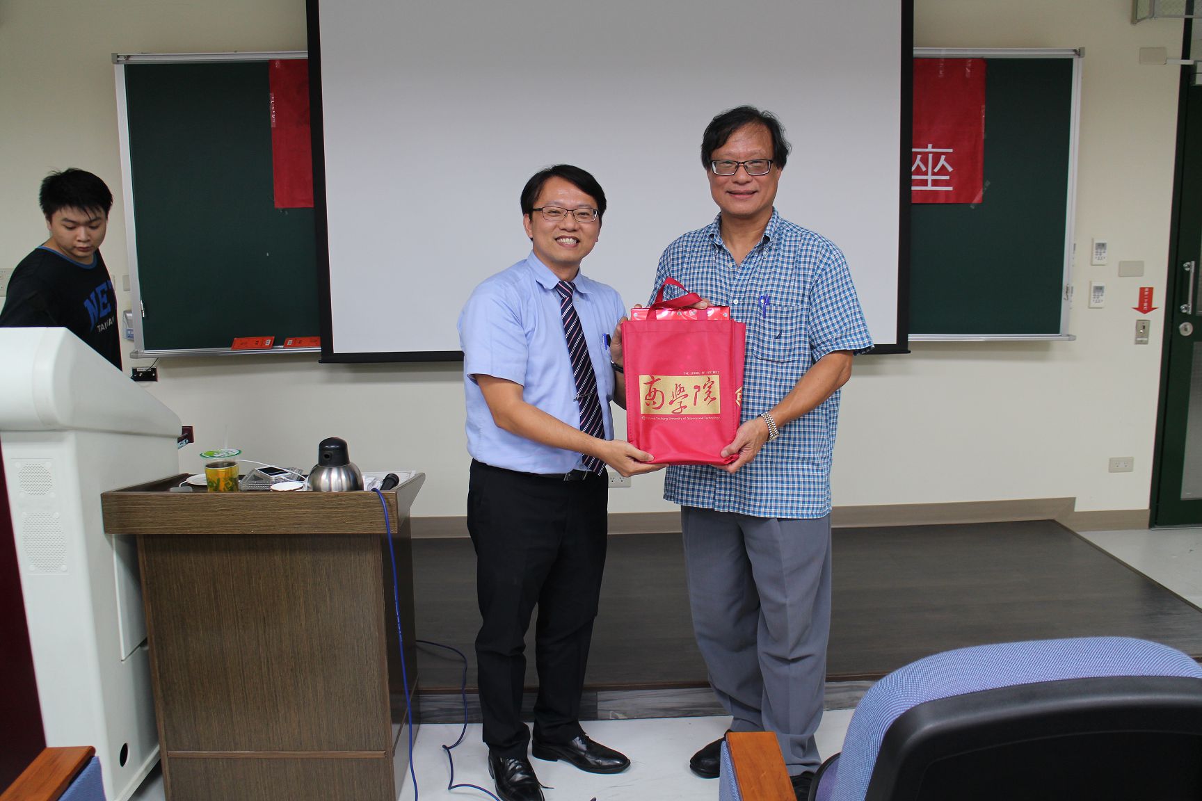 許義忠主任(左一)頒發商學院禮品致贈徐偉初老師(右一)